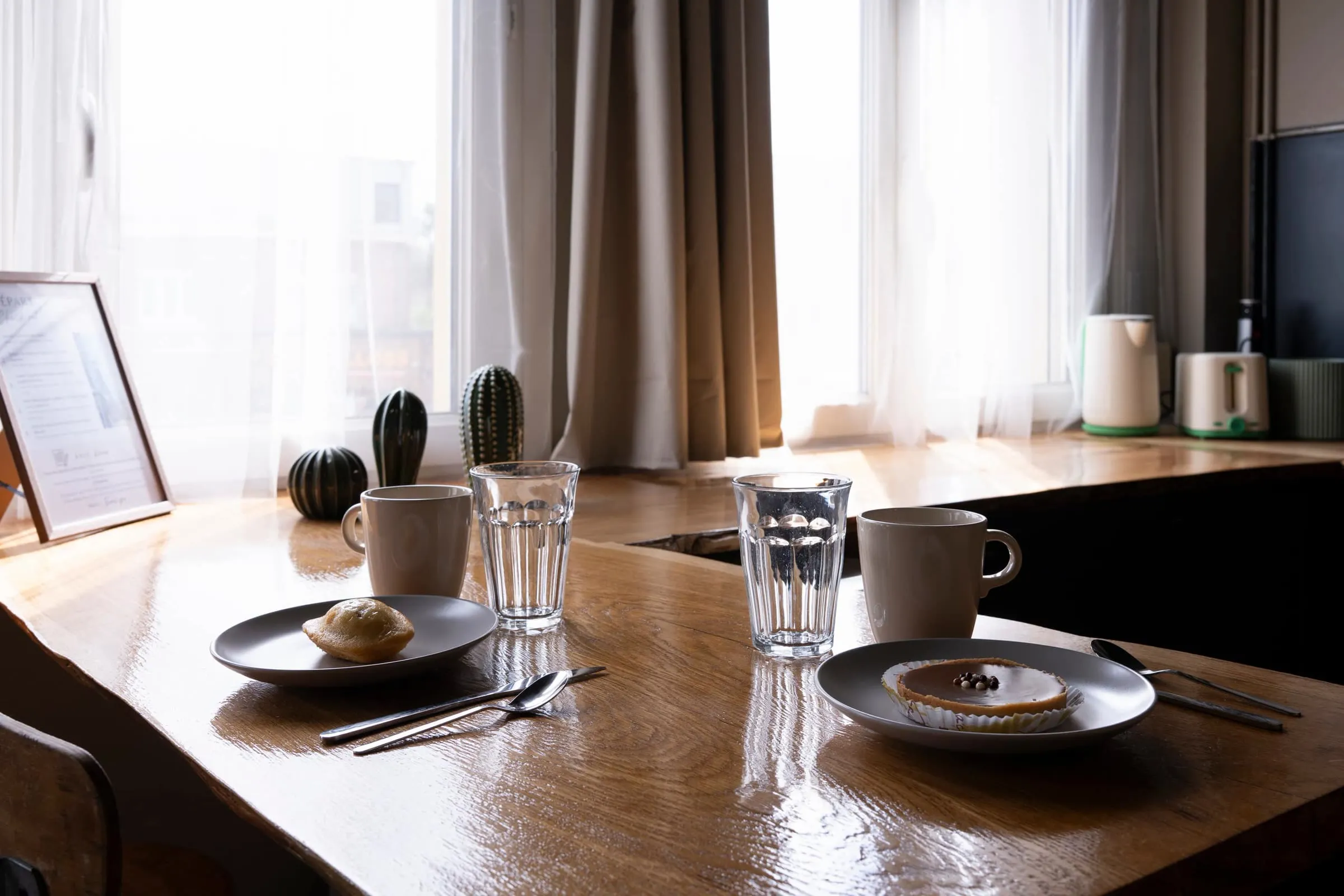 Table du petit-déjeuner dressée près de la fenêtre à La Cabane d'Alfred à Lens