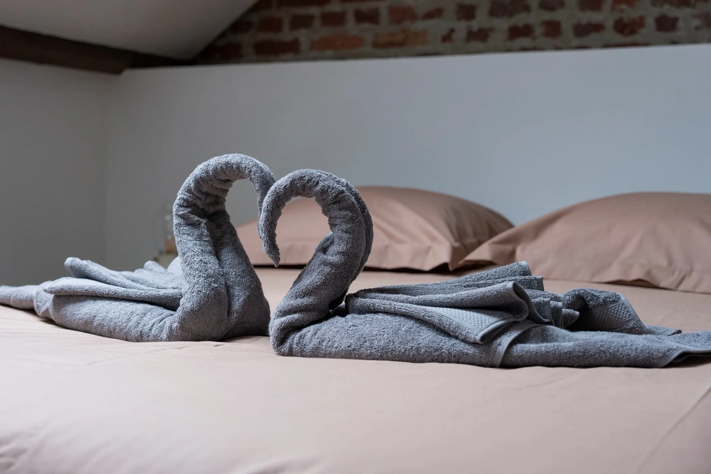 Lit au linge hôtelier et serviettes pliées en cygnes au Loft d'Alfred à Lens