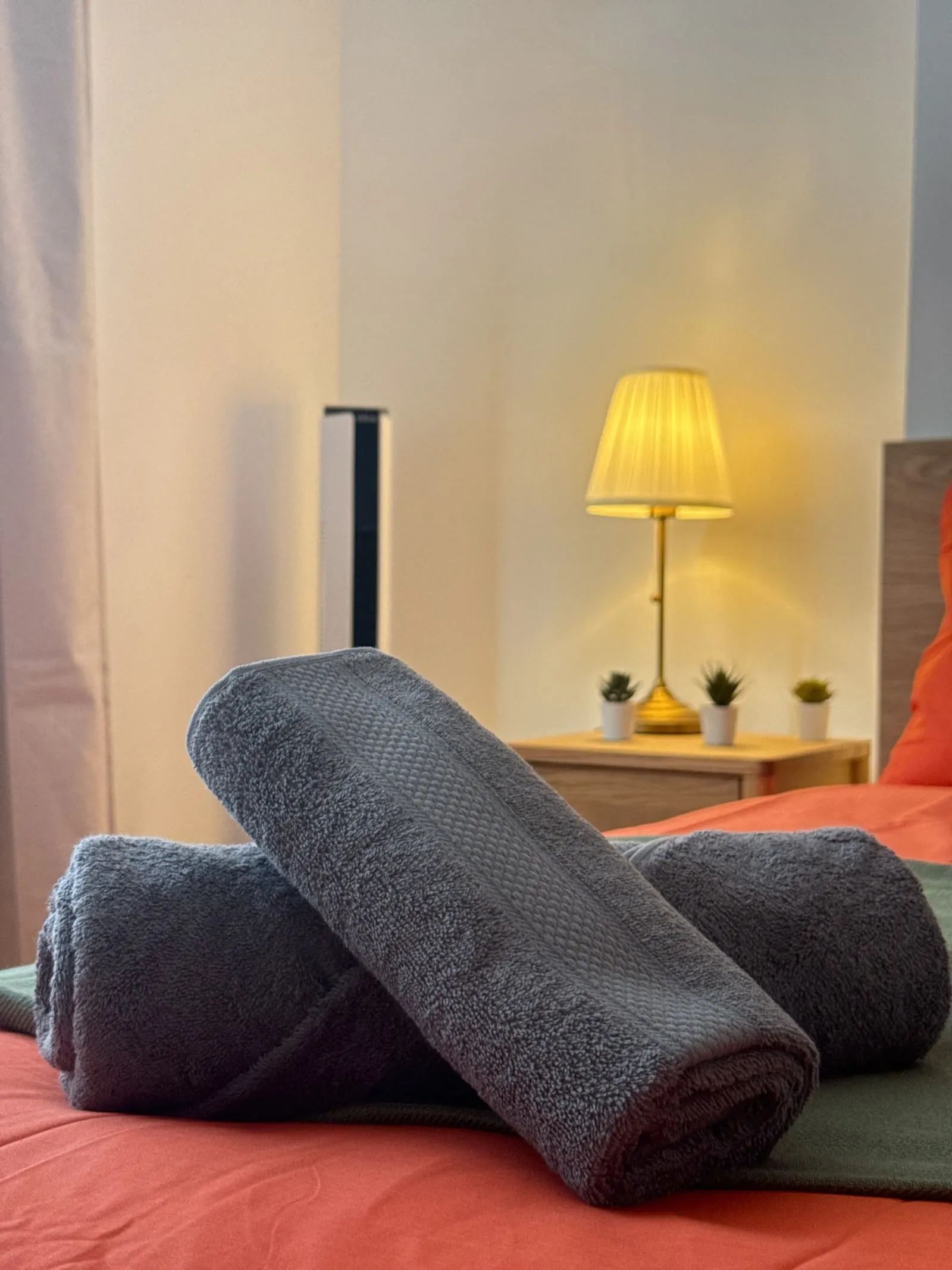 Serviettes roulées sur le lit et lampe allumée au Diderot à Lens