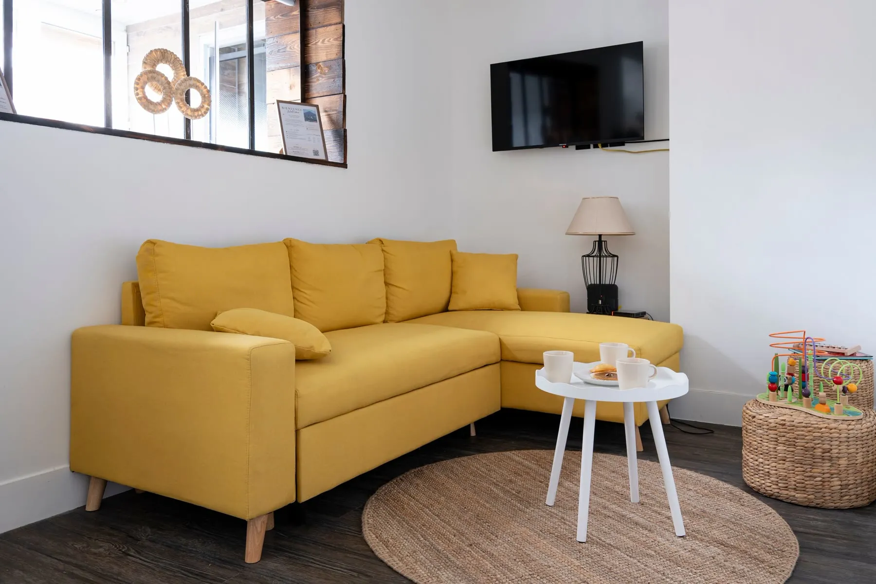 Salon de La Terrasse d'Alfred à Lens, canapé jaune et fauteuil en rotin